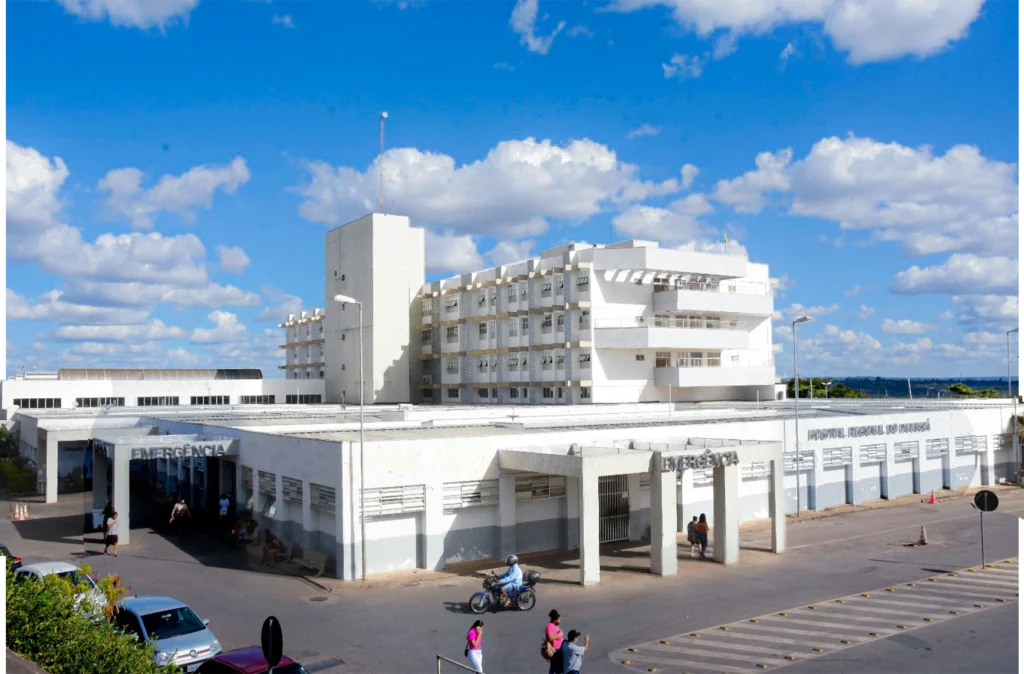 foto de um prédio retangular e todo branco, visto de forma ampla ao lado externo