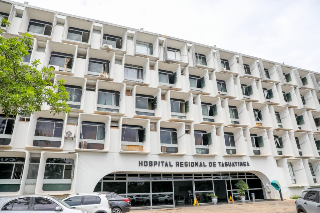 fachada toda branca e com diversas janelas em branco de um prédio de 4 andares